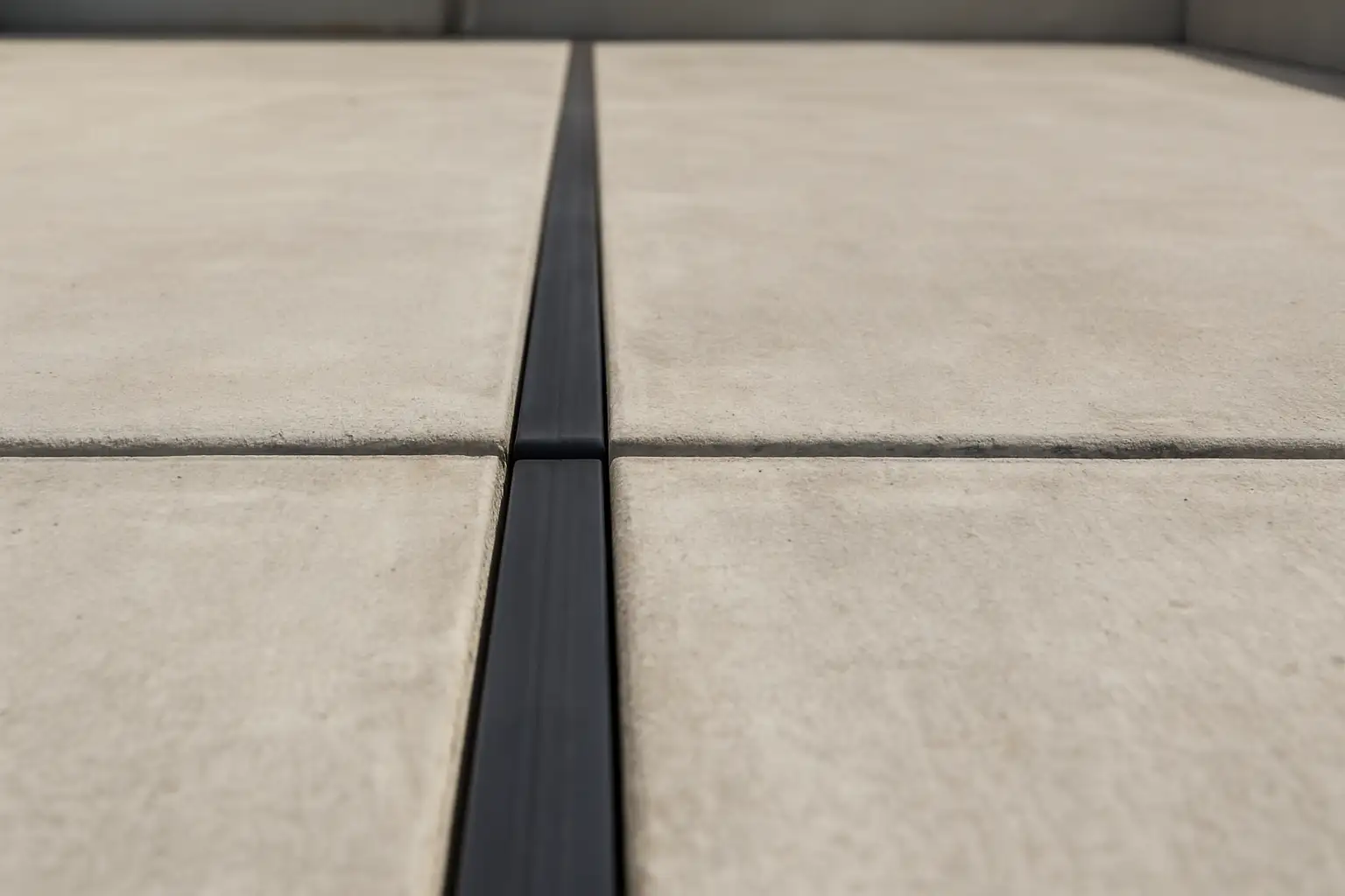 Joint de dilatation visible entre deux parties d’une dalle béton sur une terrasse
